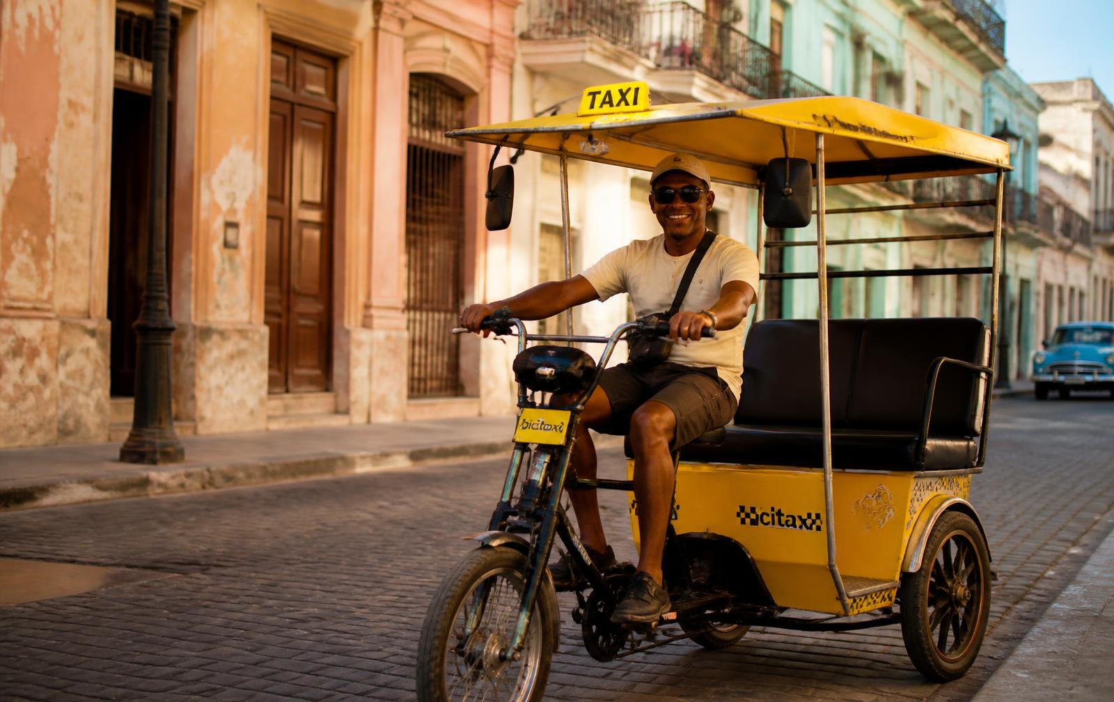 Triciclo eléctrico de pasajeros en una calle de La Habana Vieja